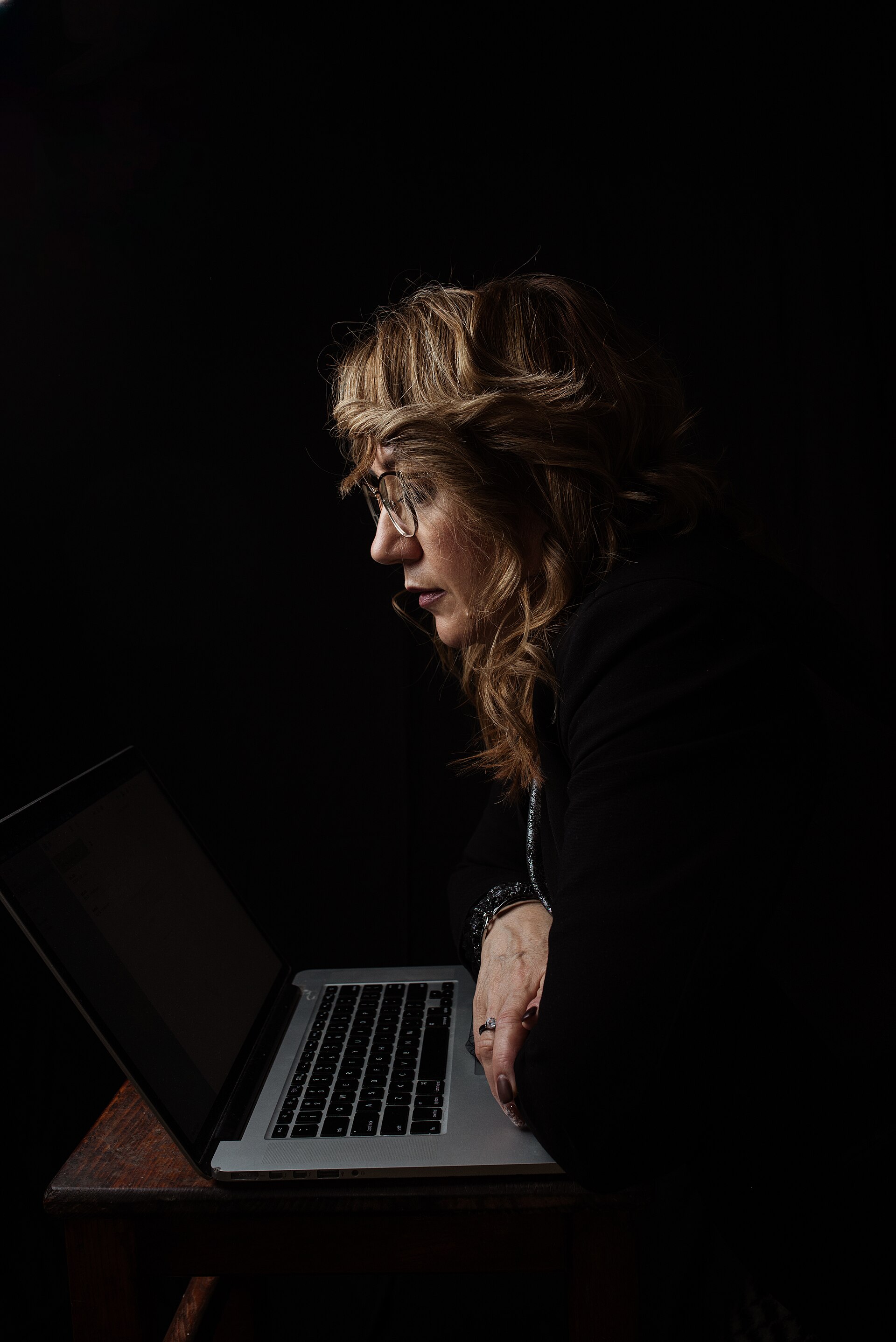 A professional working from a laptop at a real home desk