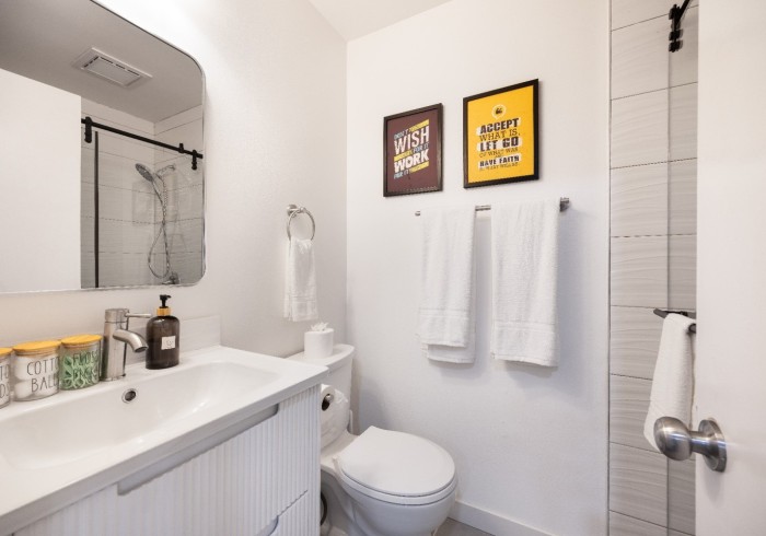 A clean bathroom with vanity, towels, and walk-in shower.